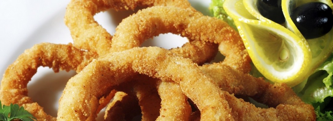 Seafood - Fried Calamari. Deep-fried Squid Dressed with Salad Leaves, Parsley, Olives and Lemon